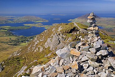 IRELAND, County Galway, Connemara, Diamond Hill, Stone pile at the summit of the hill with Ballynakill Harbour below