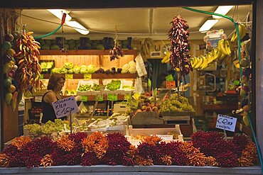 Italy, Veneto, Venice, Centro Storico, Local grocer with display of fresh fruit, vegetables and chillies Woman in interior