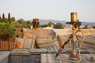 Turkey, Izmir Province, Selcuk, Ephesus, View from rooftop cafe with water pipe on table in foreground and traditional kilim textiles