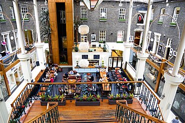 Ireland, County Dublin, Dublin City, Powerscourt Centre restaurants with people at tables beside shops in the enclosed old Georgian townhouse courtyard.