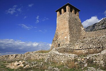 Albania, Kruja. Stone watch tower of Kruja Castle and part ruined walls.