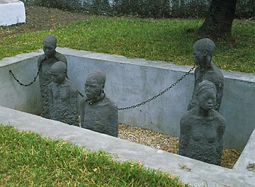 TANZANIA Zanzibar Island Zanzibar Stone Town. Sculpture depicting five slaves chained in a pit in the grounds of the Cathedral Church of Christ Anglican Cathedral.