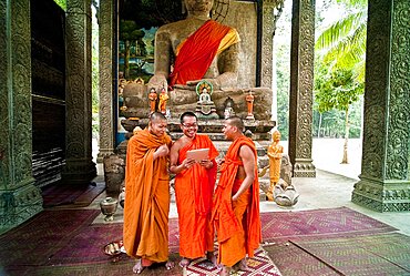 Buddhist monks laughing at a picture on a digital reading tablet, Angkor Thom, Siem Reap, Cambodia