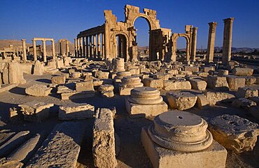 SYRIA Central Tadmur Monumental arch.  High central arch flanked by a lower arch on each side with colonnaded street part seen  behind and masonry ruins in the foreground. Palmyra  Palmyra