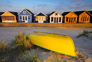 Beach huts and boat on Mudeford Spit, Mudeford, Dorset, England, United Kingdom, Europe