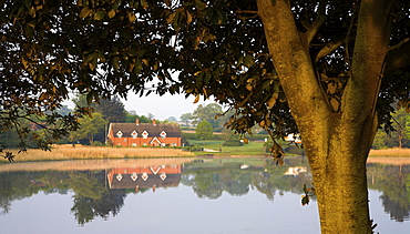 Cottages across Beaulieu Pond, New Forest, Hampshire, England, United Kingdom, Europe