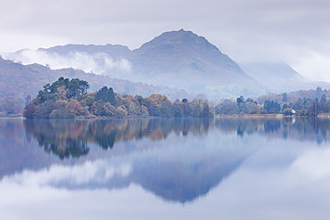 Mist hangs over the lake and island at Grasmere with Helm Crag beyond, Lake District, Cumbria, England, United Kingdom, Europe