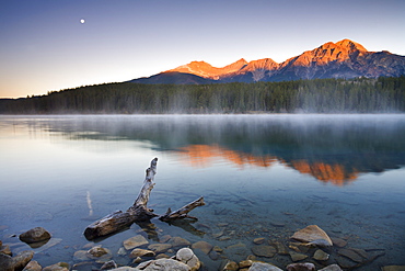 The first rays of sunshine illuminate Pyramid Mountain and reflect in Patricia Lake, Jasper National Park, UNESCO World Heritage Site, Alberta, Canada, North America