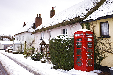 Snow covered cottages and traditional phone box in the village of Morchard Bishop, Devon, England, United Kingdom, Europe