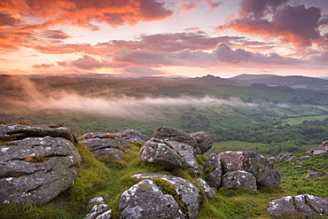 Dramatic sunset above a misty moorland near Hound Tor, Dartmoor National Park, Devon, England, United Kingdom, Europe