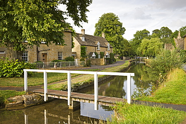 Cottages and footbridge over the River Eye in the Cotswolds village of Lower Slaughter, Gloucestershire, England, United Kingdom, Europe 