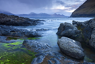 Rocky shores of Gjogv, looking towards the mountains of Kalsoy, Faroe Islands, Denmark, Europe 