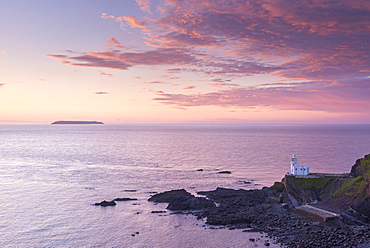 Hartland Point Lighthouse and Lundy Island beneath a colourful sunset, North Devon, England, United Kingdom, Europe