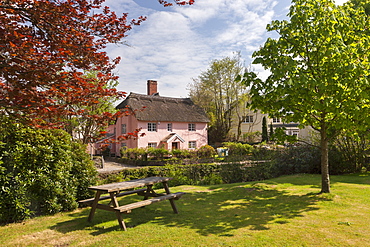 Picnic bench and pretty pink cottage in the village of Winsford, Exmoor National Park, Somerset, England, United Kingdom, Europe