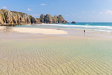 Woman walking alone on Pednvounder Beach at low tide, Porthcurno, Cornwall, England, United Kingdom, Europe