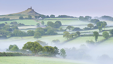 Rolling mist covered countryside surrounding Brentor Church, Dartmoor, Devon, England, United Kingdom, Europe