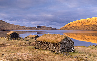 Grassed roof stone barns on the shores of Sorvagsvatn (Leitisvatn Lake) on the island of Vagar in the Faroe Islands, Denmark, Europe