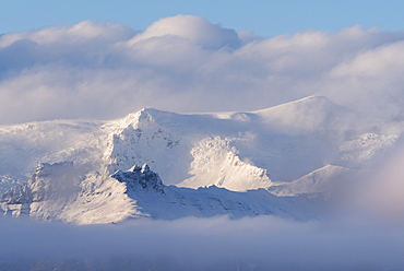 Snow covered mountains appearing through clouds, Iceland, Polar Regions