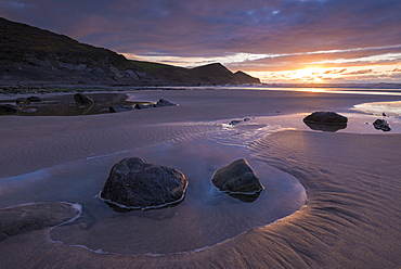 Sunset over a deserted sandy beach in winter at Crackington Haven in North Cornwall, England, United Kingdom, Europe