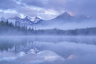 Canadian Rockies and mist reflected in Herbert Lake at sunrise, Banff National Park, UNESCO World Heritage  Site, Alberta, Canada, North America