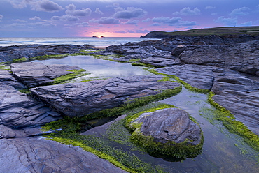 Pink sunset above Trevose Head from the rocky shores of Boobys Bay, Cornwall, England, United Kingdom, Europe