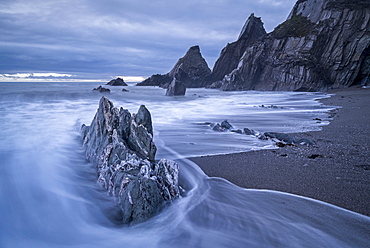 Waves surge over the dramatic rocky beach at Westcombe in the South Hams in winter, Devon, England, United Kingdom, Europe