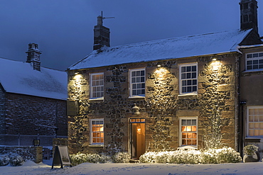 Welcoming village inn on a snowy winter evening, Bamburgh, Northumberland, England, United Kingdom, Europe