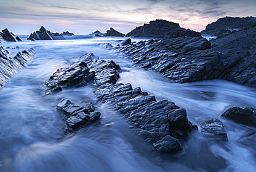 Waves and wet rock ledges at Hartland Quay in North Devon at sunset, Devon, England, United Kingdom, Europe