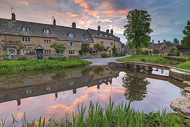 Colourful sunrise above the pretty village of Lower Slaughter in the Cotswolds, Gloucestershire, England, United Kingdom, Europe