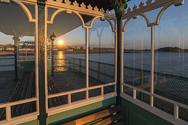 Sunset reflected in the glass shelters on Clevedon Pier, Clevedon, Somerset, England, United Kingdom, Europe