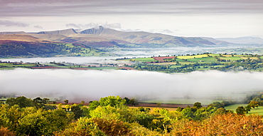 Overlooking mist covered countryside towards Pen y Fan and the Brecon Beacons mountains, Brecon Beacons National Park, Powys, Wales, United Kingdom. Europe