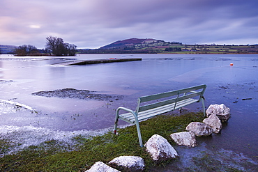 Empty bench on the frozen shores of Llangorse Lake in the Brecon Beacons National Park in winter, Powys, Wales, United Kingdom, Europe