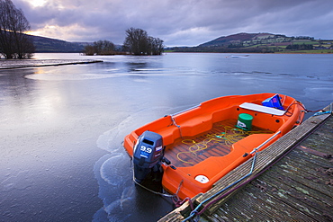 Frozen boat and water at Llangorse Lake in the Brecon Beacons National Park in winter, Powys, Wales, United Kingdom, Europe