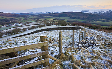 Snow dusted fence and fields looking towards Bwlch and snowy mountains beyond, Brecon Beacons National Park, Powys, Wales, United Kingdom, Europe