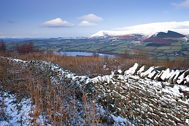 Snow dusted dry stone wall on the Allt yr Esgair looking towards Llangorse Lake and the Black Mountains, Brecon Beacons National Park, Powys, Wales, United Kingdom, Europe