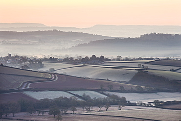 Overlooking frost and mist covered countryside at dawn in winter near the village of Silverton, Devon, England, United Kingdom, Europe