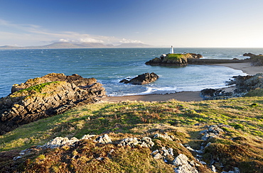 Early evening view of Pilots Cove and the beacon lighthouse Twr Bach on Llanddwyn Island, with the mountains of the Llyn Peninsula on the distant horizon, Llanddwyn Island, Newborough, Anglesey, North Wales, Wales, United Kingdom, Europe