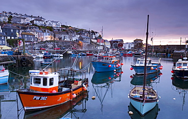 Fishing boats crowd a placid Mevagissey Harbour at dawn, Mevagissey, South Cornwall, England, United Kingdom, Europe