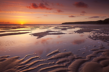 Sunset over the Atlantic Ocean, from the sandy shores of Bedruthan Steps beach, Cornwall, England, United Kingdom, Europe