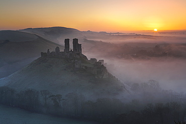 Mist surrounds the ruins of Corfe Castle at sunrise, Dorset, England, United Kingdom, Europe