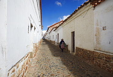 Woman walking along alleyway, Sucre, UNESCO World Heritage Site, Bolivia, South America