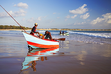 Fishermen launching fishing boats on Tofo beach, Tofo, Inhambane, Mozambique, Africa