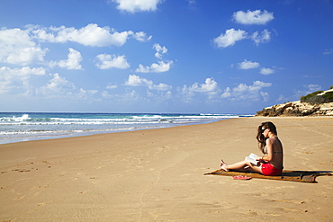 Woman reading on beach, Tofo, Inhambane, Mozambique, Africa