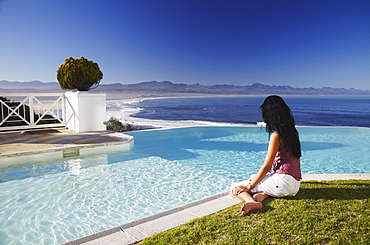 Woman relaxing poolside at Plettenberg Bay Hotel, Plettenberg Bay, Western Cape, South Africa, Africa