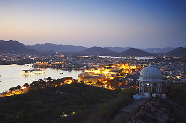 View of City Palace and Lake Palace Hotel at sunset, Udaipur, Rajasthan, India, Asia