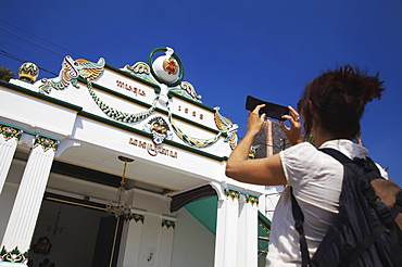 Woman taking photo of entrance of Kraton (Palace of Sultans), Yogyakarta, Java, Indonesia, Southeast Asia, Asia