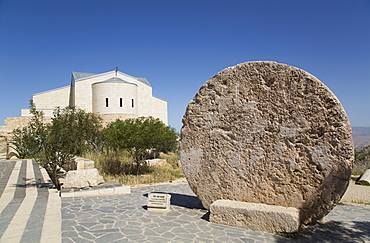 Abu Badd, a rolling stone used to fortify a door, Moses Memorial Church in the background, Mount Nebo, Jordan, Middle East