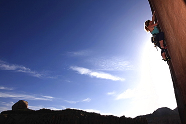 A rock climber tackles an overhanging wall on the cliffs of Indian Creek, a famous rock climbing area near Moab, south eastern Utah, United States of America, North America