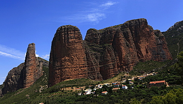 The small village of Riglos below huge conglomerate towers rising over a thousand feet above the plains near Heusca and Jaca, northern Aragon, southern Pyrenees region, Spain, Europe