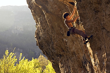 A climber tackles a very difficult route on the rock known as Dromadaire (The Dromedary) by the Tarn river, Gorges du Tarn, near Millau and Rodez, Massif Central, south west France, Europe